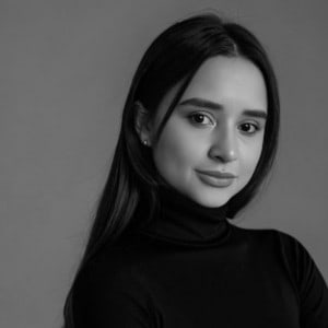 A greyscale headshot of Daniele Marut, a woman with dark hair wearing a black shirt.